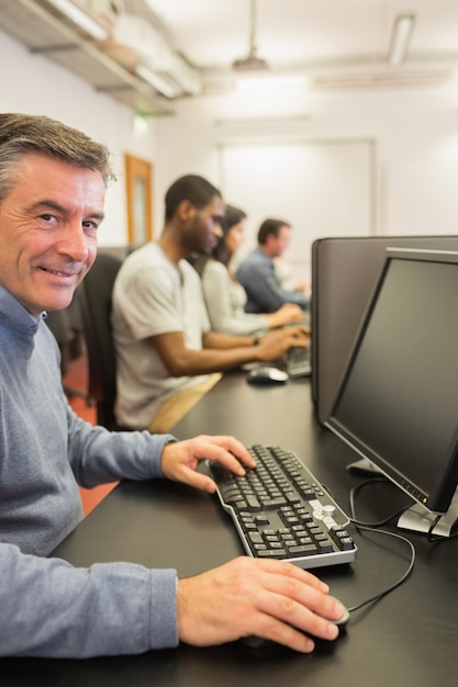 Lächelnder Mann, der mit dem Computer arbeitet