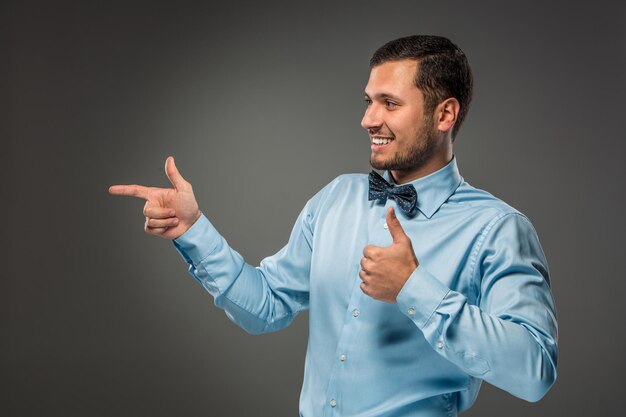 Lächelnder Mann, der mit einem Zeigefinger auf etwas zeigt