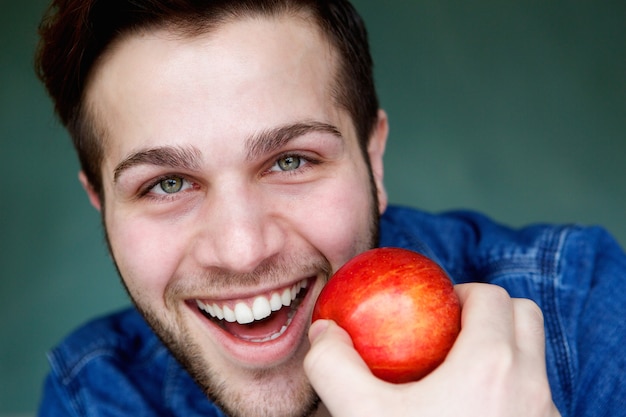 Lächelnder Mann, der roten Apfel anhält