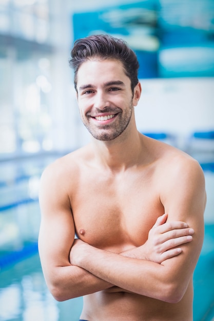 Lächelnder Mann mit den Armen gekreuzt am Pool
