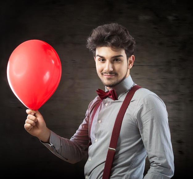 Lächelnder Mann mit einem roten Ballon