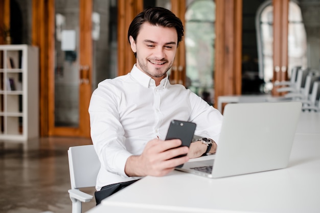 Lächelnder Mann schaut auf sein Handy