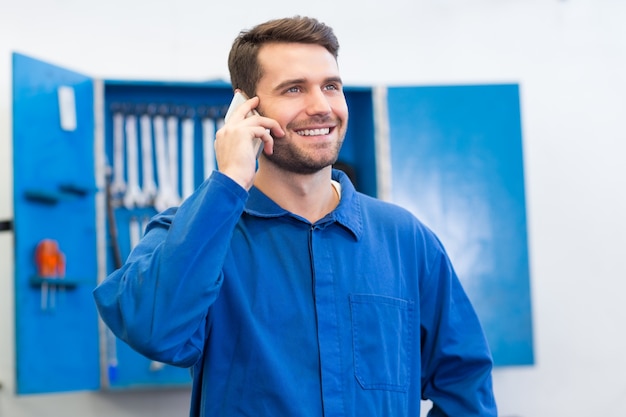 Lächelnder Mechaniker am Telefon