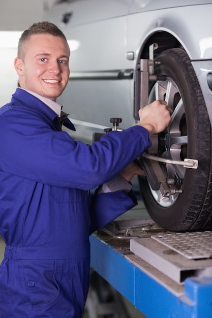 Lächelnder Mechaniker, der ein Autorad ändert