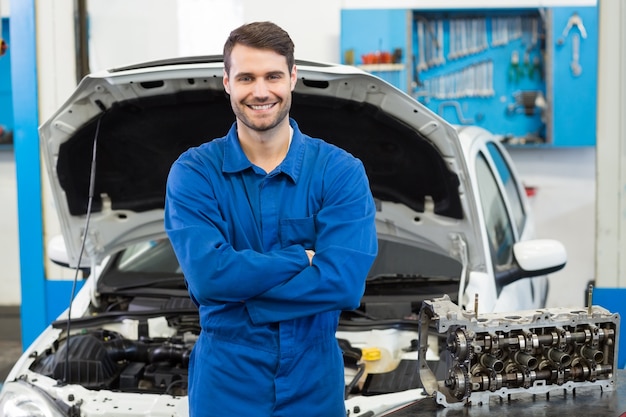 Lächelnder Mechaniker, der Kamera betrachtet