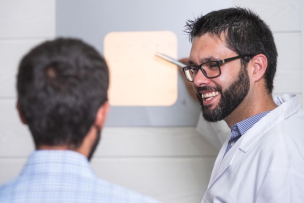 Foto lächelnder optiker testet das auge eines patienten in einer klinik