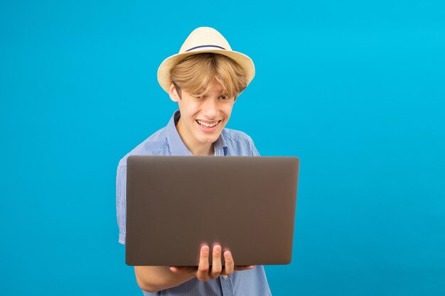 Lächelnder positiver Geschäftsmann, der einen Laptop in den Händen hält und Blogger schreibt, der Beiträge in sozialen Netzwerken erstellt und mit Followern chattet