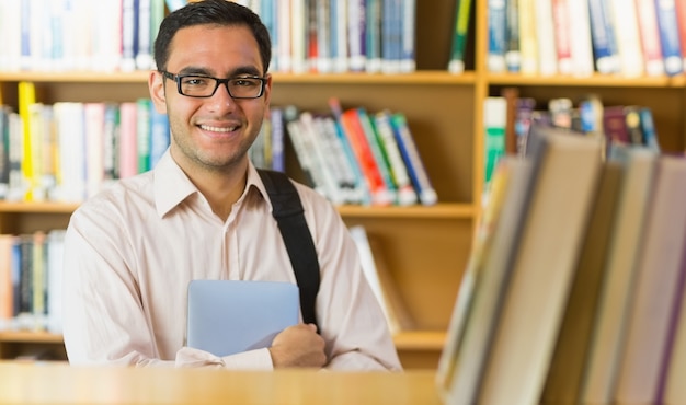 Lächelnder reifer Student mit Tablet-PC in der Bibliothek