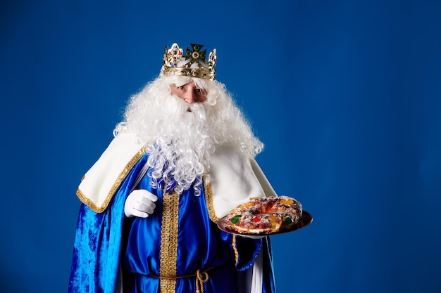 Lächelnder Rey Mago mit einem Quotroscon de Reyesquot in der Hand auf blauem Hintergrund