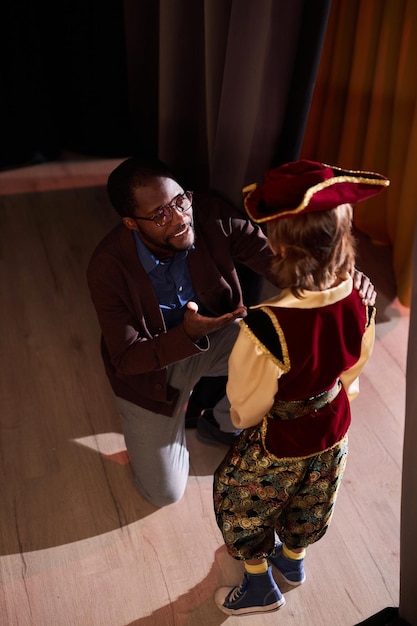 Lächelnder Schauspiellehrer spricht mit einem Jungen