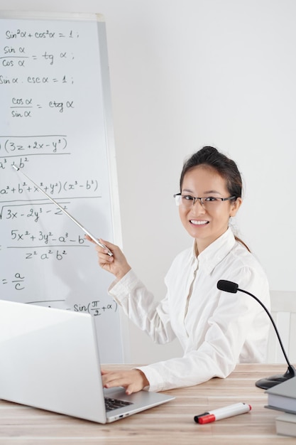 Lächelnder Schullehrer, der Online-Unterricht für Schüler aufzeichnet und Gleichungen und Formeln erklärt