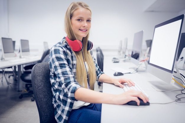 Foto lächelnder student, der an computer an der universität arbeitet