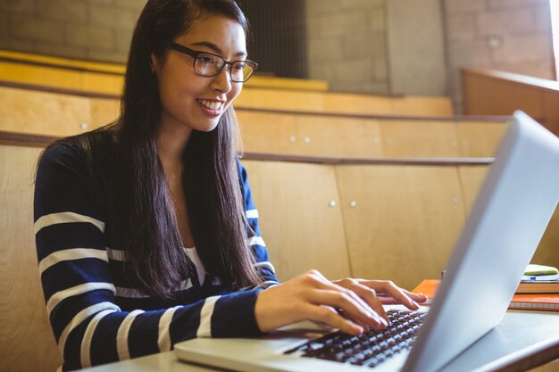 Lächelnder Student, der Laptop verwendet