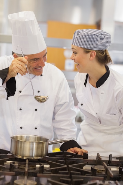 Lächelnder Student und Lehrer, welche die Suppe besprechen