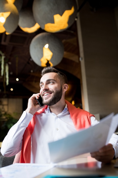 Lächelnder Unternehmer, der telefonisch spricht