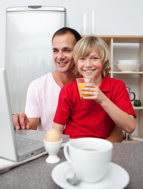 Lächelnder Vater und sein Sohn, die frühstücken