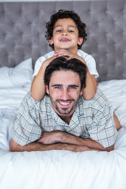 Lächelnder Vater und Sohn auf dem Bett