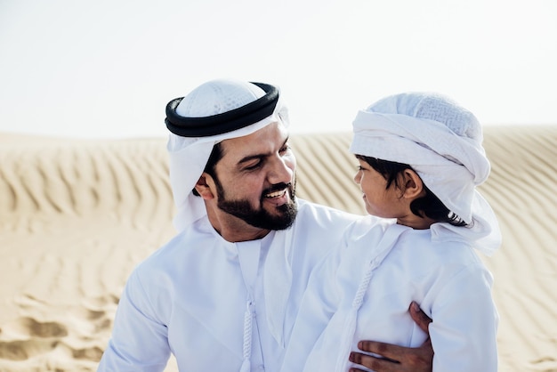 Lächelnder Vater und Sohn genießen es, während sie in der Wüste stehen