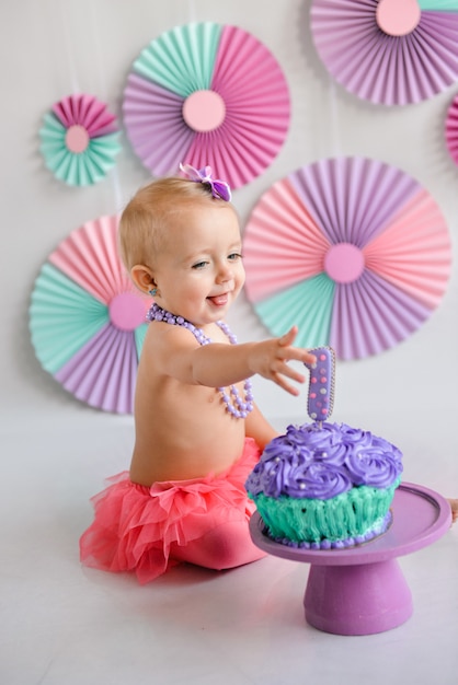 Foto lächelndes alles gute zum geburtstagmädchen wurde in einen kuchen geschmiert