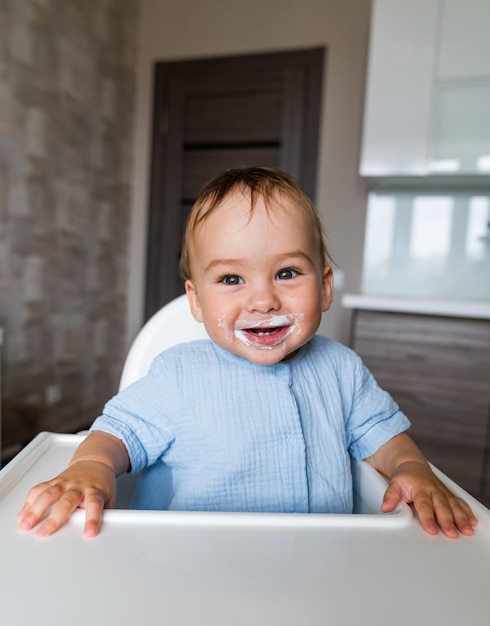 Lächelndes Baby, das Nahrung auf Küche isst Ernährung des Kindes