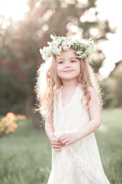 Lächelndes Baby mit Blumenkranz im Freien