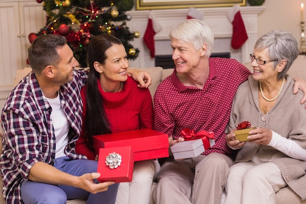 Lächelndes Familienholdinggeschenk auf Sofa