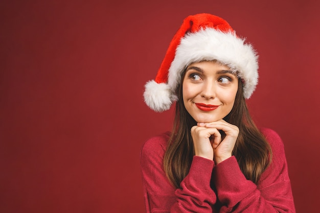 Lächelndes glückliches Mädchen in der Weihnachtsmannmütze