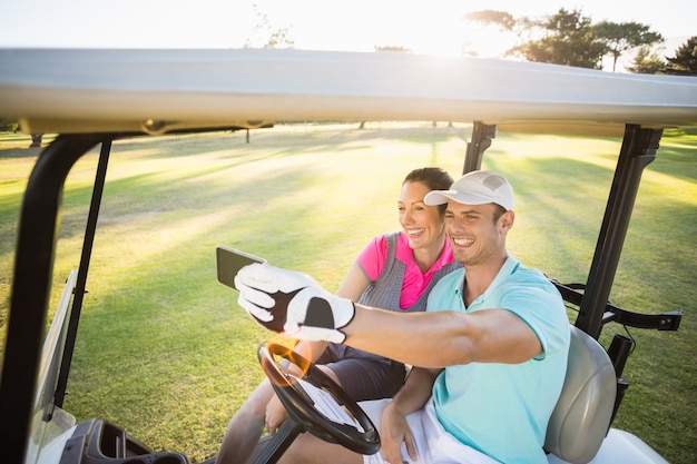 Lächelndes Golferpaar, das Selfie nimmt