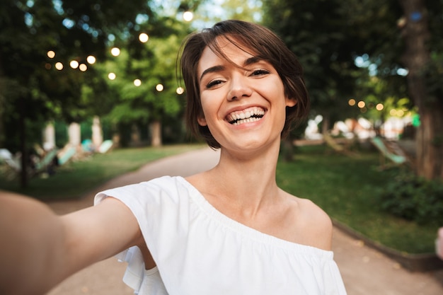 Lächelndes junges Mädchen, das ein Selfie nimmt