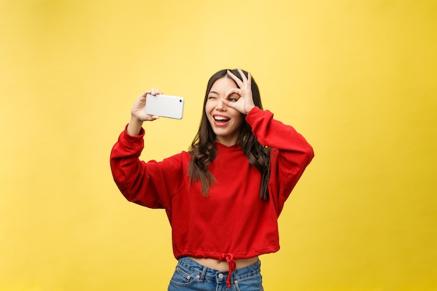 Lächelndes junges Mädchen, das Selfie-Foto auf Smartphone macht