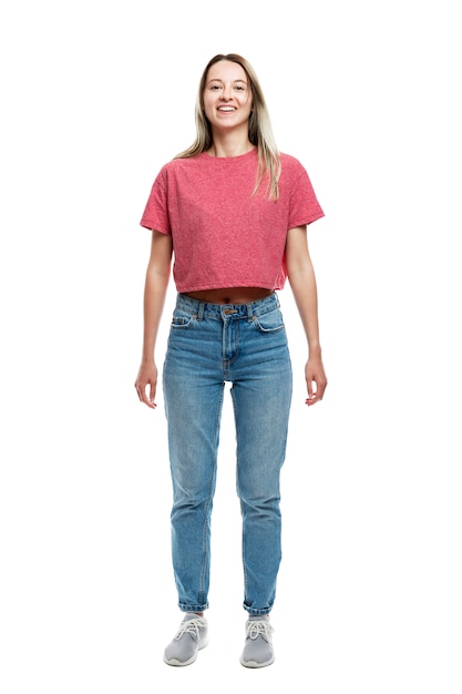 Lächelndes junges Mädchen in einem roten Trägershirt und in Jeans. Vollständige Höhe. . Vertikale.