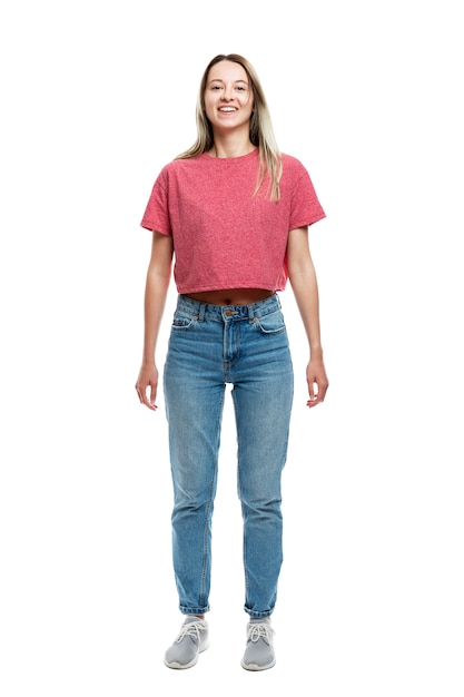 Lächelndes junges Mädchen in einem roten Trägershirt und in Jeans. Vollständige Höhe. . Vertikale.