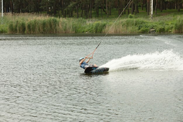 Lächelndes Kind, das Wake-Board lernt.