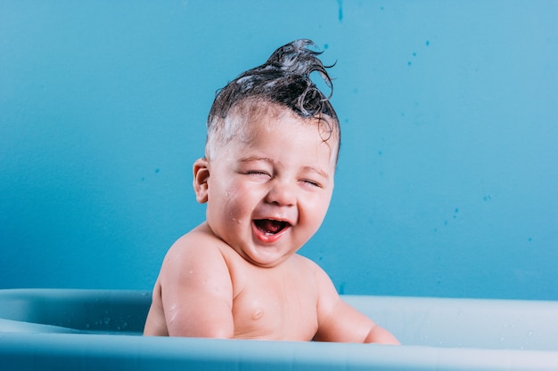 Lächelndes Kind im Badezimmer mit blauem buntem Hintergrund