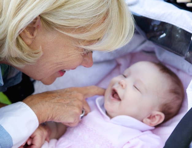 Lächelndes kitzelndes Baby der Großmutter