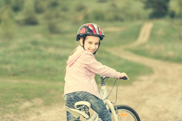 Lächelndes kleines Mädchen, das Fahrrad fährt, wandte sich ab