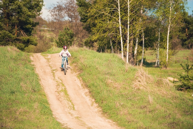 Lächelndes kleines mädchen, das fahrrad fährt