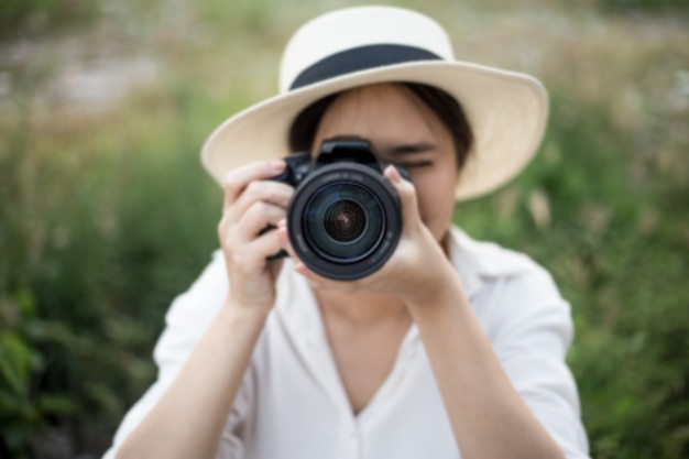 Lächelndes Lebensstilporträt des Sommers des netten Frauenwanderers, der Spaß in der Stadt in Thailand am Abend mit dem Kamerareisefoto des Fotografen macht Bilder im Hippie-Arthut hat