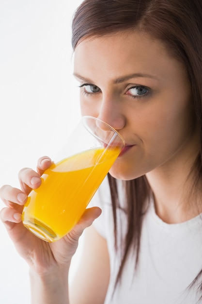 Lächelndes Mädchen, das ein Glas Orangensaft trinkt