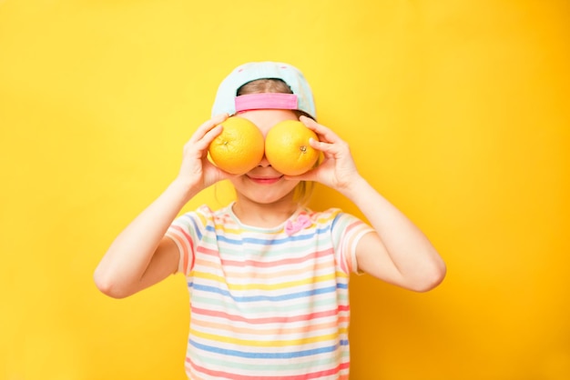 Foto lächelndes mädchen, das zwei gelbe grapefruit-zitrusfrüchte in den händen hält, die ihre augen bedecken gesunde ernährung, ernährung, glück, spaßkonzept