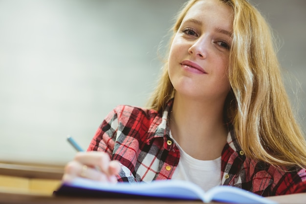 Foto lächelndes studentenschreiben auf notenkorb