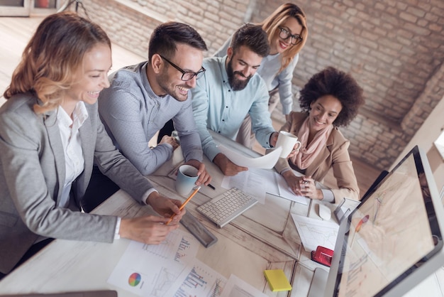 Foto lächelndes team von geschäftsleuten, die im unternehmen zusammenarbeiten