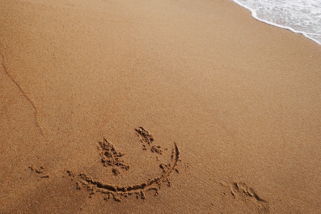 Lächelngesicht auf Sand