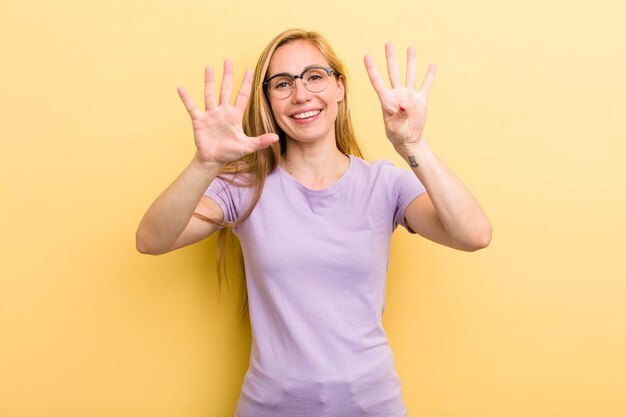 Lächelt und sieht freundlich aus und zeigt Nummer neun oder neun, wobei die Hand nach unten zählt