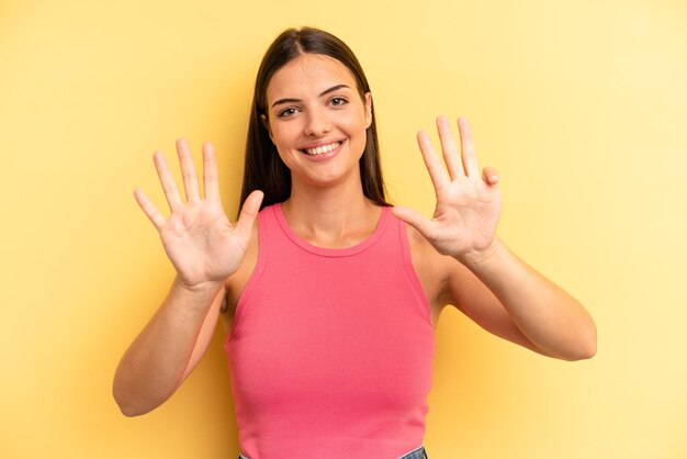 Lächelt und sieht freundlich aus und zeigt Nummer neun oder neun, wobei die Hand nach unten zählt