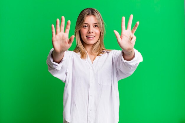 Lächelt und sieht freundlich aus und zeigt Nummer neun oder neun, wobei die Hand nach unten zählt