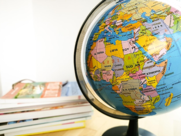 Foto länder und kontinente mit farbenfroher karte auf dem globus mit büchern im hintergrund bildungskonzept