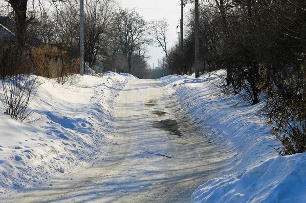 Ländliche gefrorene rutschige Asphaltstraße im Winter