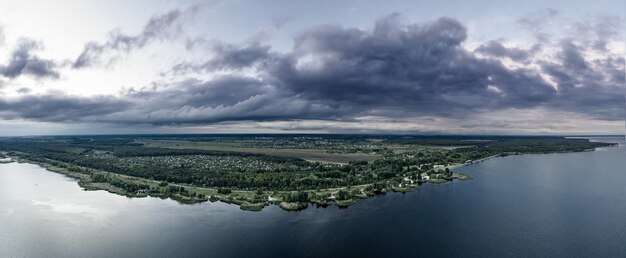 Foto ländliche sommersonnenunterganglandschaft mit fluss und dramatischem buntem himmel mit natürlichem hintergrund aus der vogelperspektive