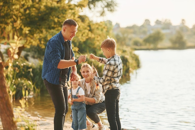 Ländliche Szene Vater und Mutter mit Sohn und Tochter beim gemeinsamen Angeln im Freien im Sommer